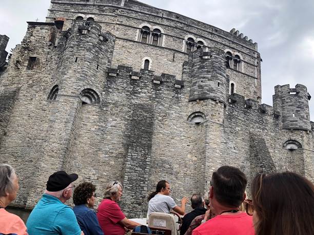 A group of people sitting in front of a castle

Description automatically generated with medium confidence